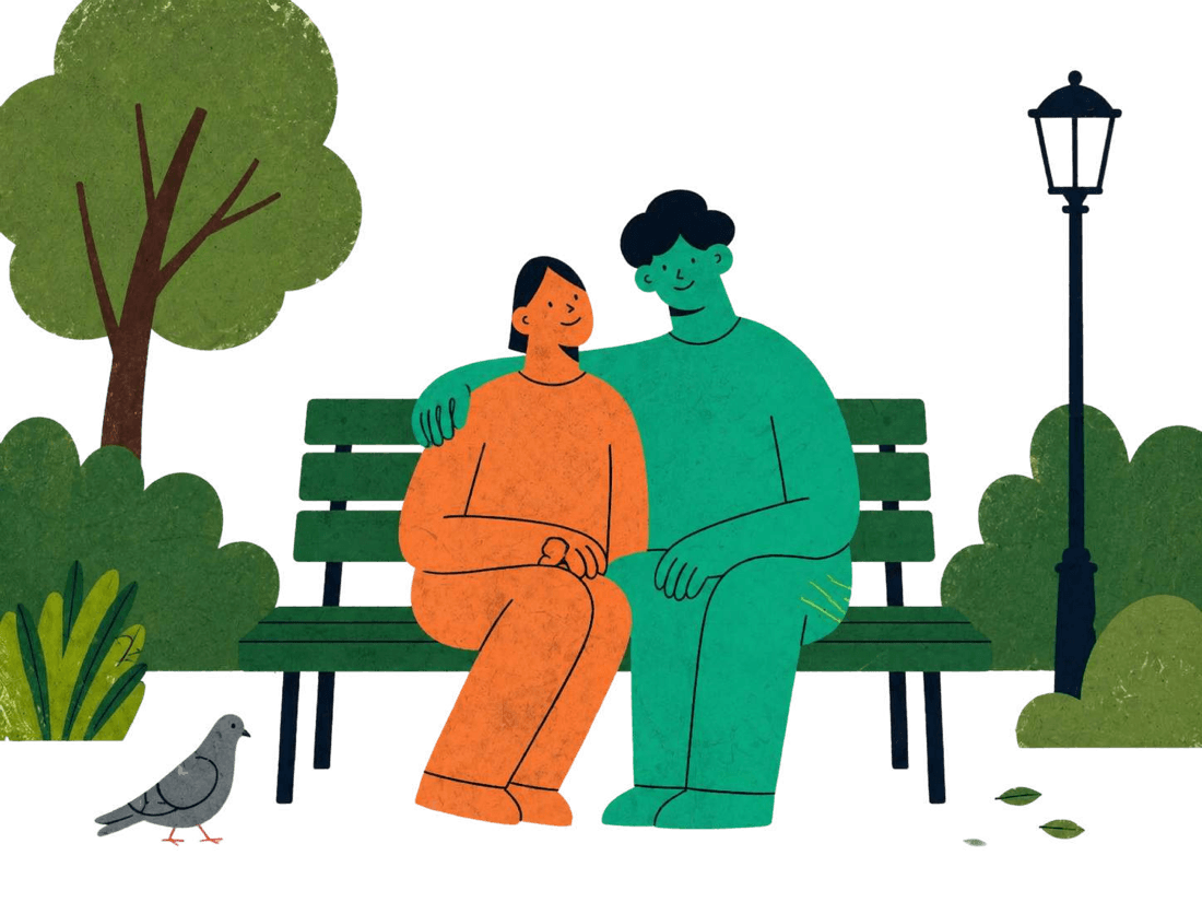 A couple sitting together on a park bench